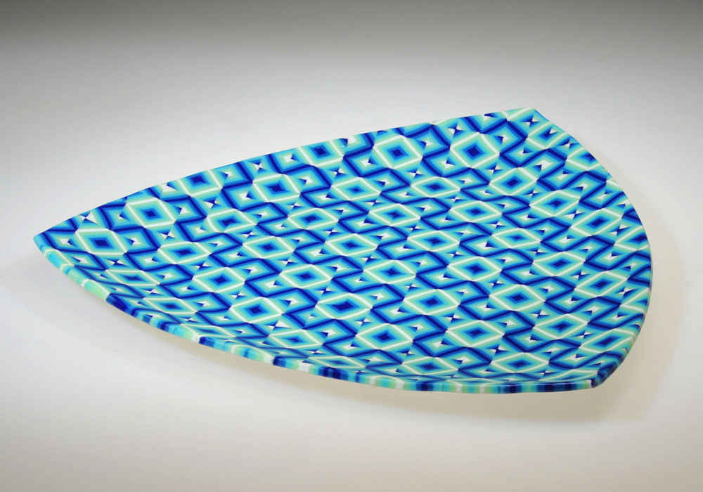 A large rounded triangle shaped platter with a blue geometric pattern